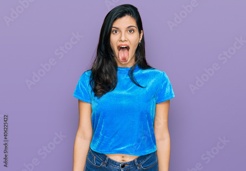 Young hispanic woman wearing casual clothes sticking tongue out happy with funny expression. emotion concept. photo