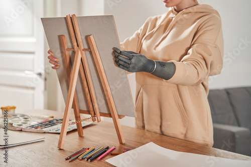 Female artist with artificial limb preparing to paints picture