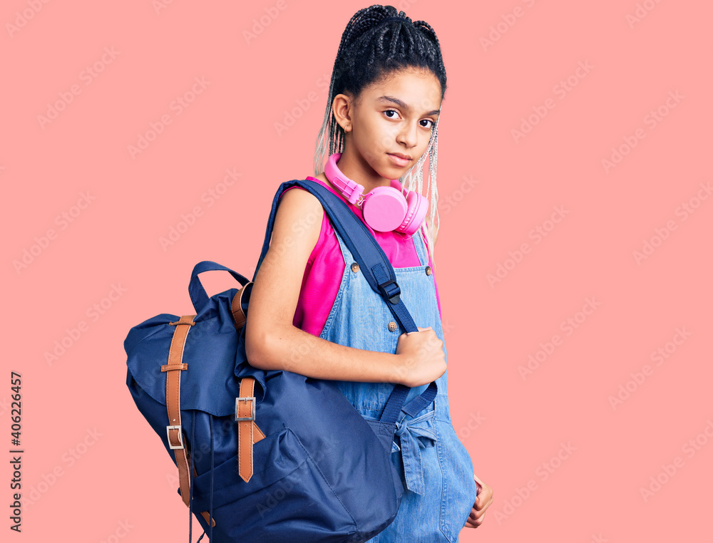 Cute african american girl holding student backpack using backpack thinking attitude and sober expression looking self confident Cute african american girl holding student backpack using backpack thinking attitude and sober expression looking self confident