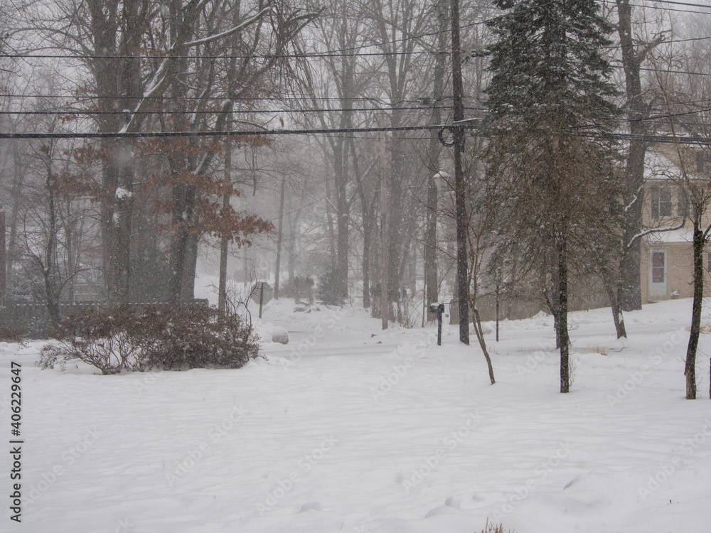 suburban neighborhood during a snow storm in winter