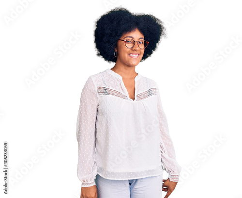 Young african american girl wearing casual clothes looking positive and happy standing and smiling with a confident smile showing teeth
