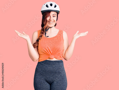 Young beautiful woman wearing bike helmet celebrating victory with happy smile and winner expression with raised hands