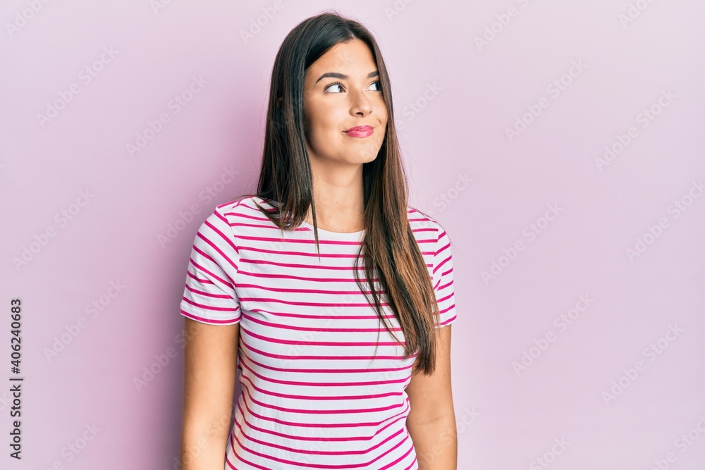 Young brunette woman wearing casual clothes over pink background smiling looking to the side and staring away thinking. Young brunette woman wearing casual clothes over pink background smiling looking to the side and staring away thinking.