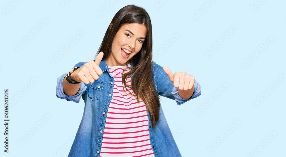 Young brunette woman wearing casual clothes approving doing positive gesture with hand, thumbs up smiling and happy for success. winner gesture. Young brunette woman wearing casual clothes approving doing positive gesture with hand, thumbs up smiling and happy for success. winner gesture.