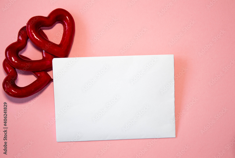 Valentine's day congratulation. Red rose and greeting card with heart sign on pink background top view copy space Valentine's day congratulation. Red rose and greeting card with heart sign on pink background top view copy space