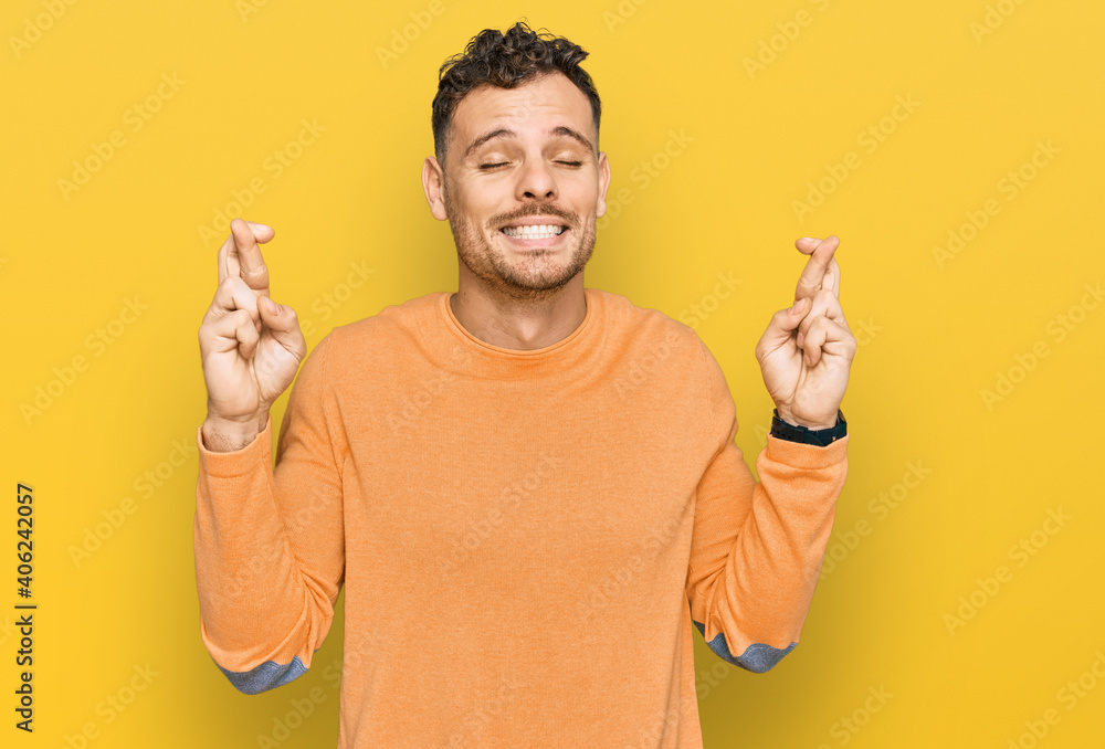 Young hispanic man wearing casual clothes gesturing finger crossed smiling with hope and eyes closed. luck and superstitious concept. Young hispanic man wearing casual clothes gesturing finger crossed smiling with hope and eyes closed. luck and superstitious concept.