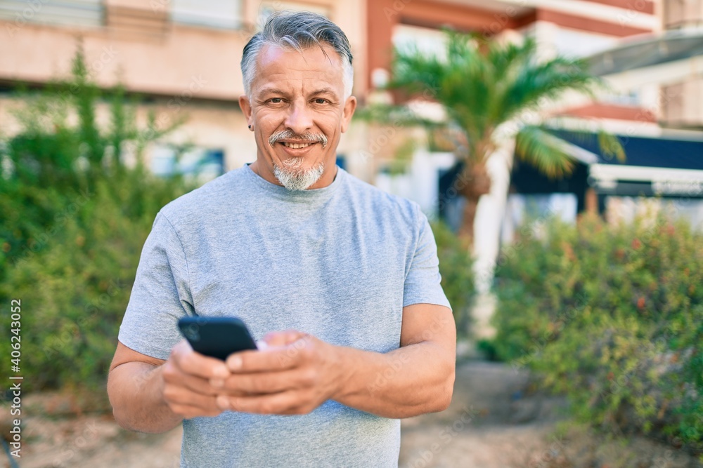 Middle age hispanic grey-haired man smiling happy using smartphone at the park. Middle age hispanic grey-haired man smiling happy using smartphone at the park.