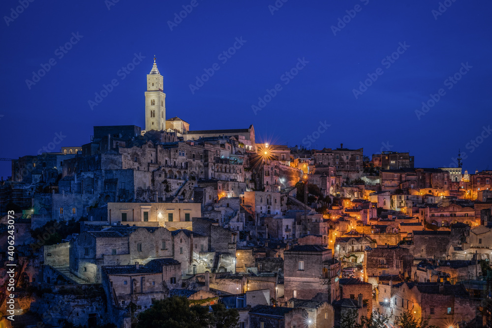 Scenic night view at blue hour of Matera with the illuminated bell tower of Matera cathedral, Basilicata, Italy