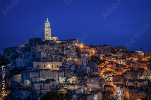 Scenic night view at blue hour of Matera with the illuminated bell tower of Matera cathedral, Basilicata, Italy