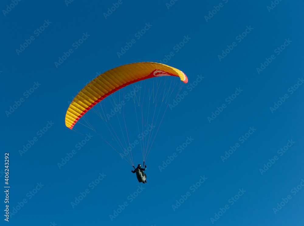 A beautiful view of a paraglide flying gliding on a clear blue sky at the golden hour with a nice wind windy breeze on a sunny day A beautiful view of a paraglide flying gliding on a clear blue sky at the golden hour with a nice wind windy breeze on a sunny day