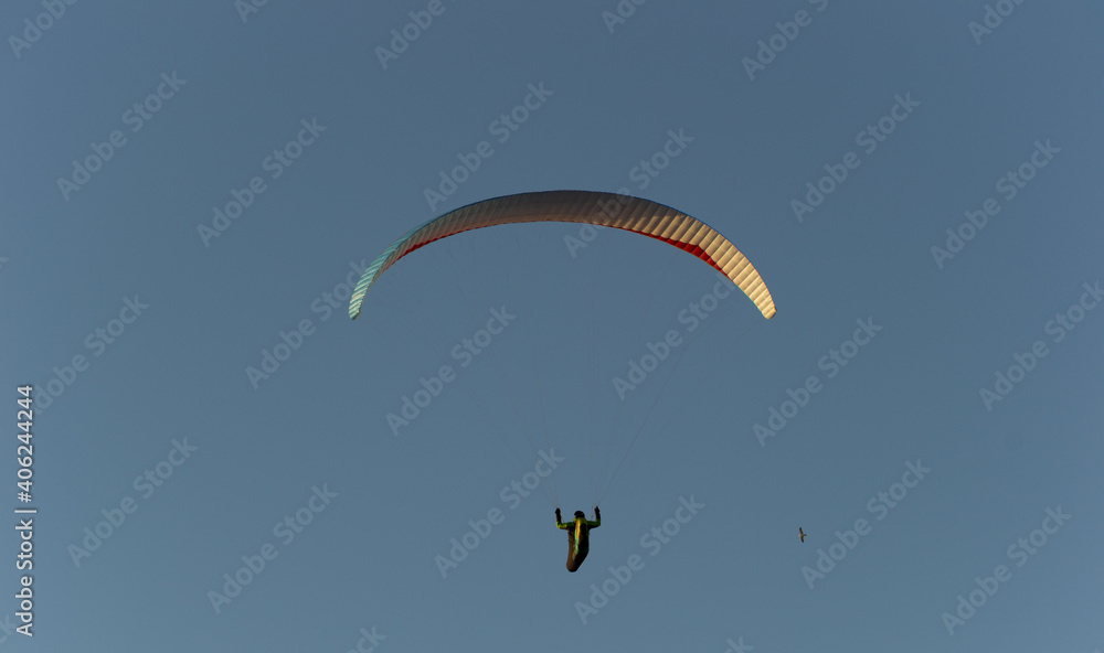 A beautiful view of a paraglide flying gliding on a clear blue sky at the golden hour with a nice wind windy breeze on a sunny day A beautiful view of a paraglide flying gliding on a clear blue sky at the golden hour with a nice wind windy breeze on a sunny day