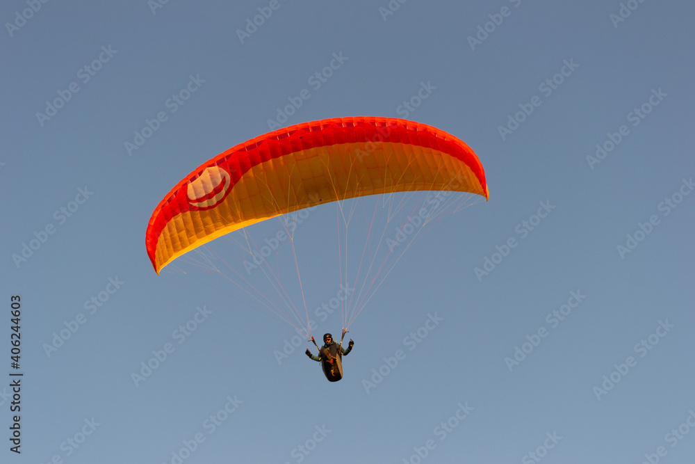 A beautiful view of a paraglide flying gliding on a clear blue sky at the golden hour with a nice wind windy breeze on a sunny day A beautiful view of a paraglide flying gliding on a clear blue sky at the golden hour with a nice wind windy breeze on a sunny day