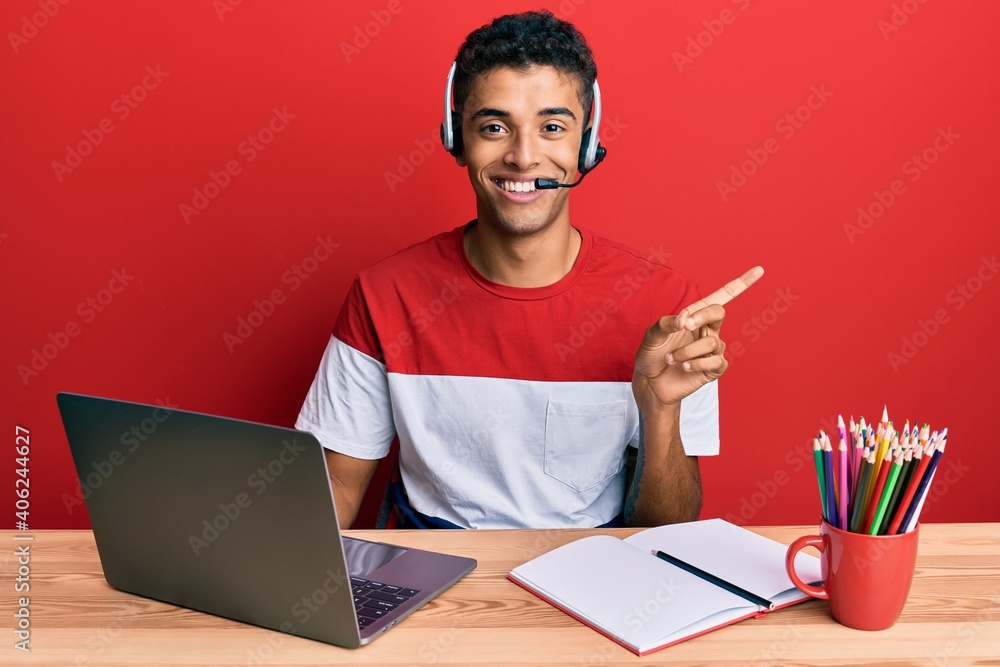 Young handsome african american man working at the office wearing operator headset smiling happy pointing with hand and finger to the side Young handsome african american man working at the office wearing operator headset smiling happy pointing with hand and finger to the side