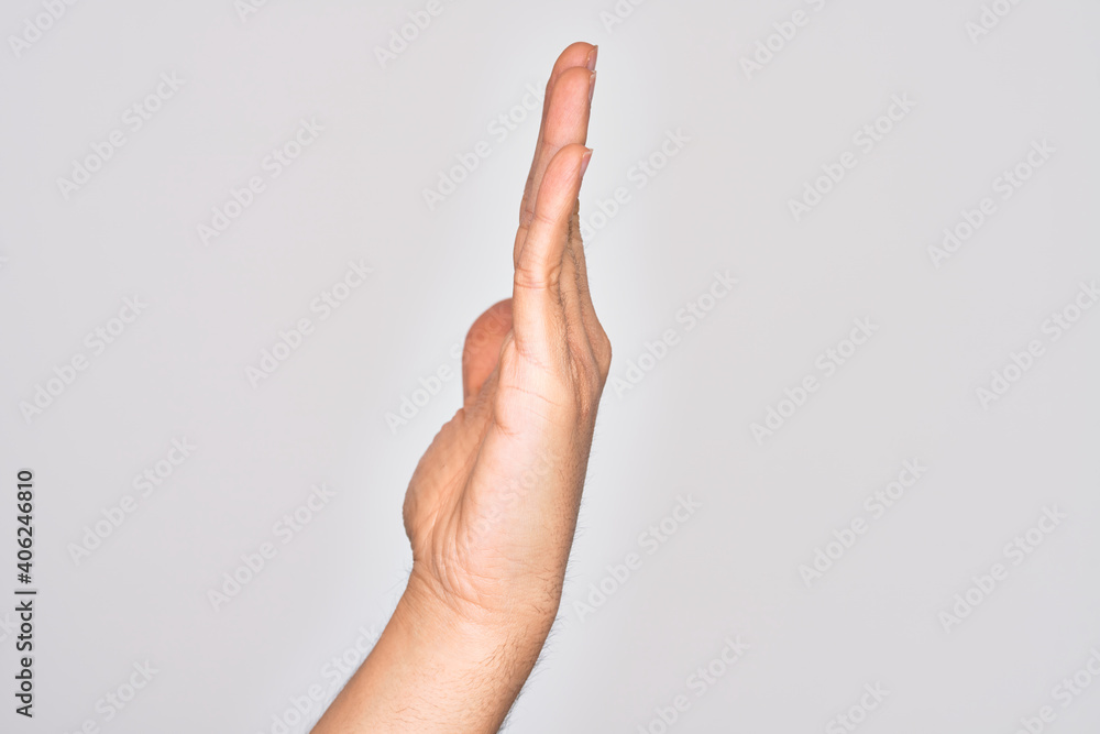 Hand of caucasian young man showing fingers over isolated white background showing side of stretched hand, pushing and doing stop gesture Hand of caucasian young man showing fingers over isolated white background showing side of stretched hand, pushing and doing stop gesture