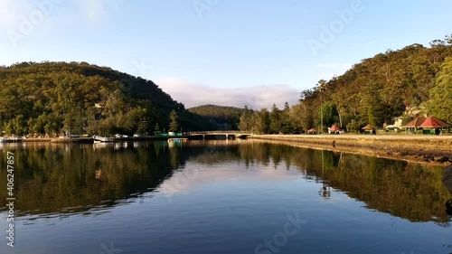 Time-lapse video of a river with reflections of luxury boats, bridge, mountains, trees and clouds on water, Cowan Creek, Ku-ring-gai Chase National park, Sydney, New South Wales, Australia
 photo