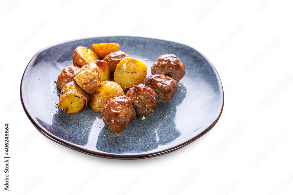 Fried potatoes in uniform and meat cutlets in a plate with greens on a white isolated background. Fried potatoes in uniform and meat cutlets in a plate with greens on a white isolated background.