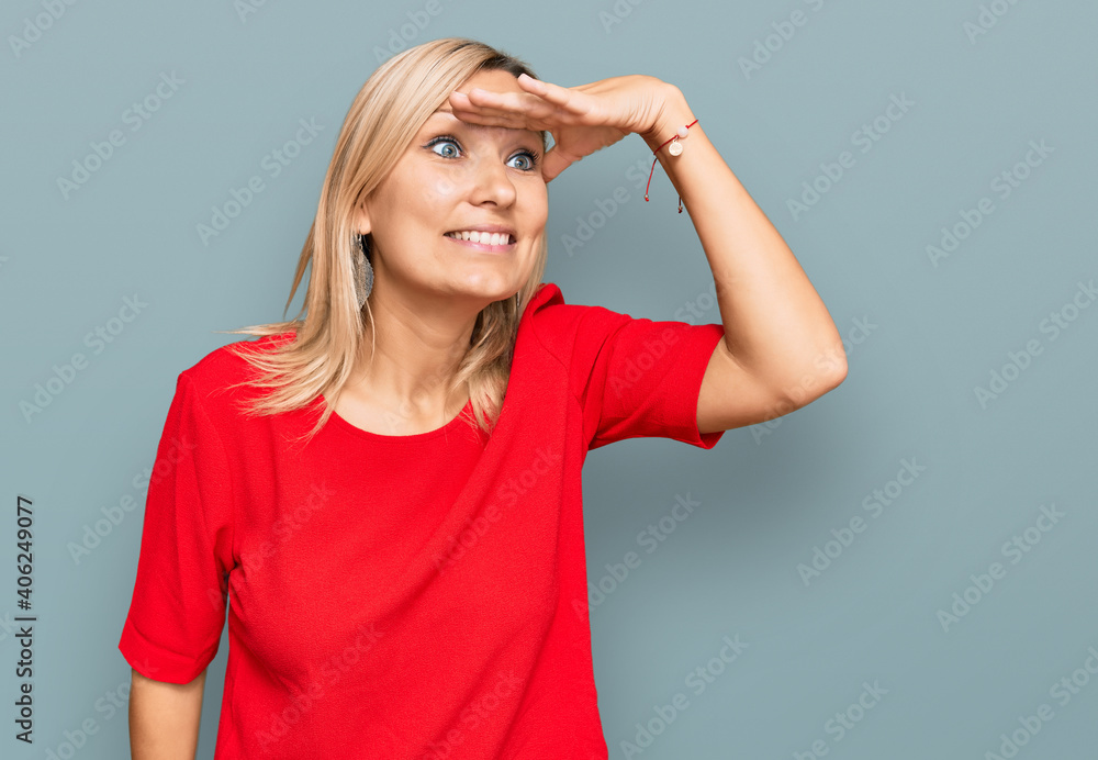 Fototapeta premium Middle age caucasian woman wearing casual clothes very happy and smiling looking far away with hand over head. searching concept.