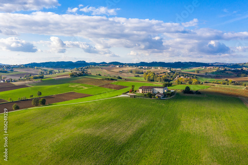 Aerial view of Monferrato countryside, Italian landscape with bright colors. Rural estate in the middle of green fields, scenic sky, copy space
