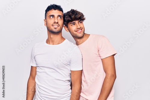 Young gay couple wearing casual clothes looking away to side with smile on face  natural expression. laughing confident.