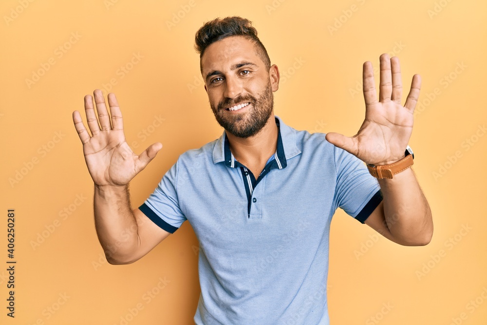 Handsome man with beard wearing casual clothes showing and pointing up with fingers number ten while smiling confident and happy. Handsome man with beard wearing casual clothes showing and pointing up with fingers number ten while smiling confident and happy.