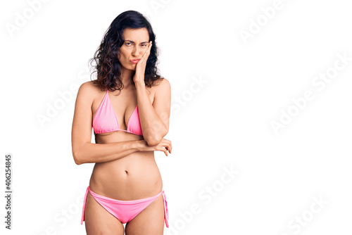 Young beautiful hispanic woman wearing bikini thinking looking tired and bored with depression problems with crossed arms. © Krakenimages.com