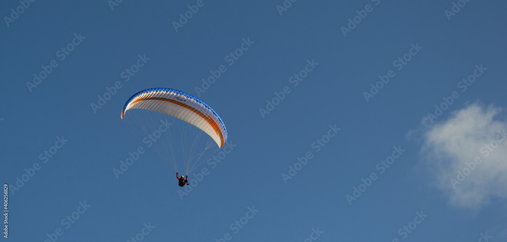 A beautiful view of a paraglide flying gliding on a clear blue sky at the golden hour with a nice wind windy breeze on a sunny day A beautiful view of a paraglide flying gliding on a clear blue sky at the golden hour with a nice wind windy breeze on a sunny day