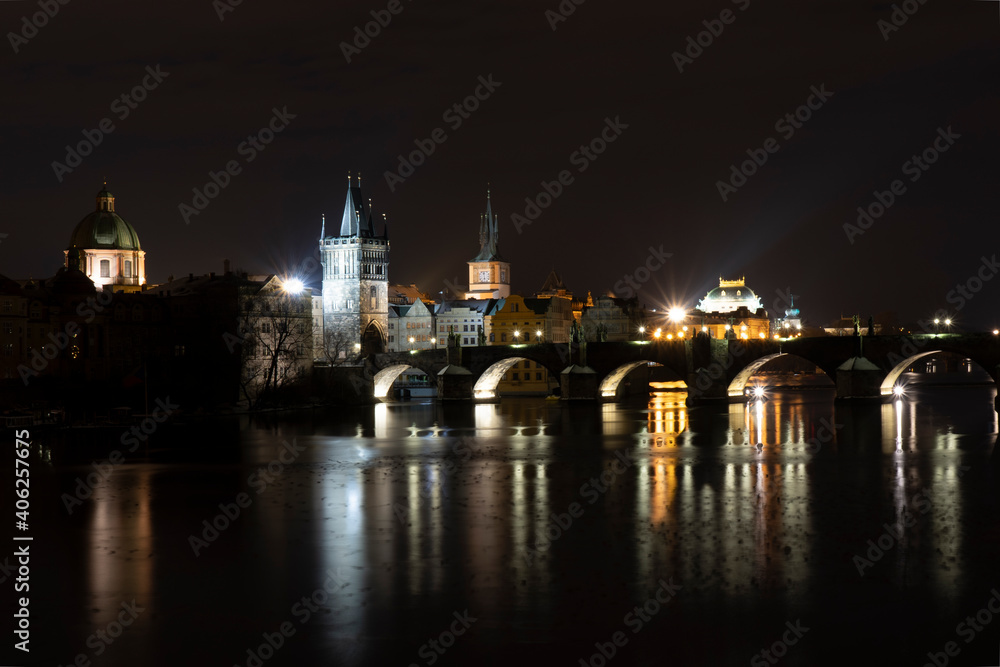 .Charles Bridge on the Vltava River and light from street lights in the center of Prague in winter