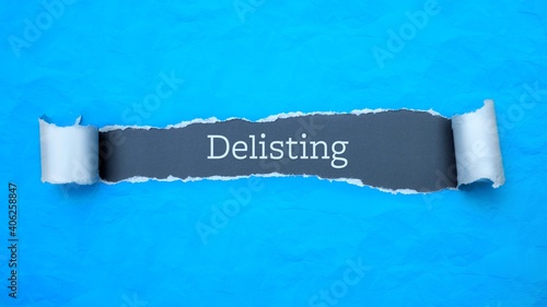 Delisting. Blue torn paper banner with text label. Word in gray hole. photo