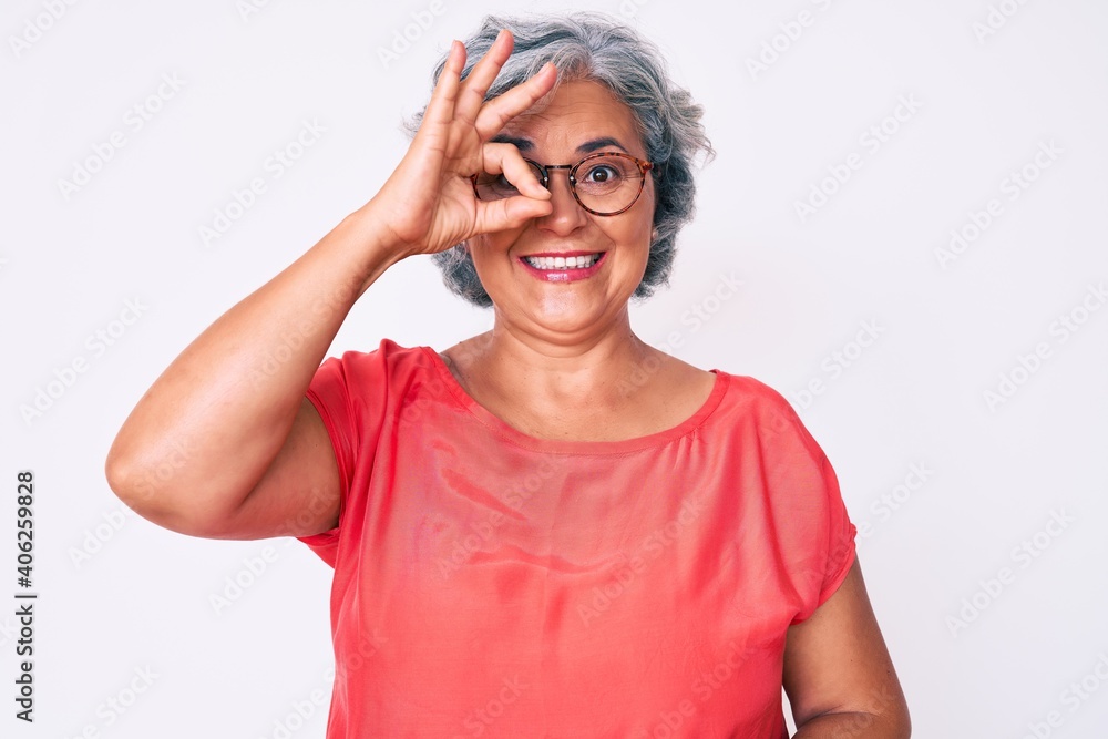 Senior hispanic grey- haired woman wearing casual clothes and glasses doing ok gesture with hand smiling, eye looking through fingers with happy face. Senior hispanic grey- haired woman wearing casual clothes and glasses doing ok gesture with hand smiling, eye looking through fingers with happy face.