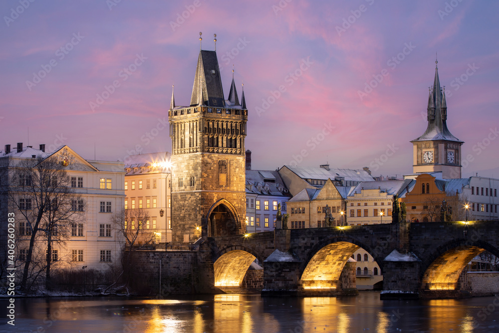 .Charles Bridge on the Vltava River and statues on the bridge and light from the street lights and a fallen dream in winter in the early evening in the center of Prague
