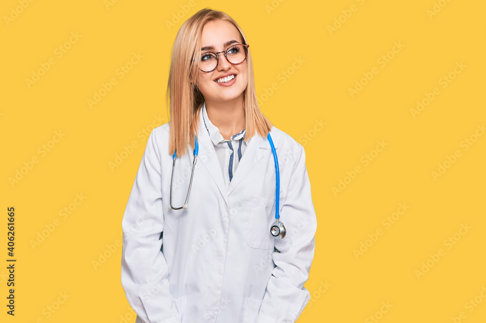 Beautiful caucasian woman wearing doctor uniform and stethoscope looking away to side with smile on face, natural expression. laughing confident. Beautiful caucasian woman wearing doctor uniform and stethoscope looking away to side with smile on face, natural expression. laughing confident.