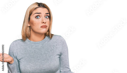 Young caucasian woman wearing casual clothes clueless and confused expression with arms and hands raised. doubt concept. © Krakenimages.com