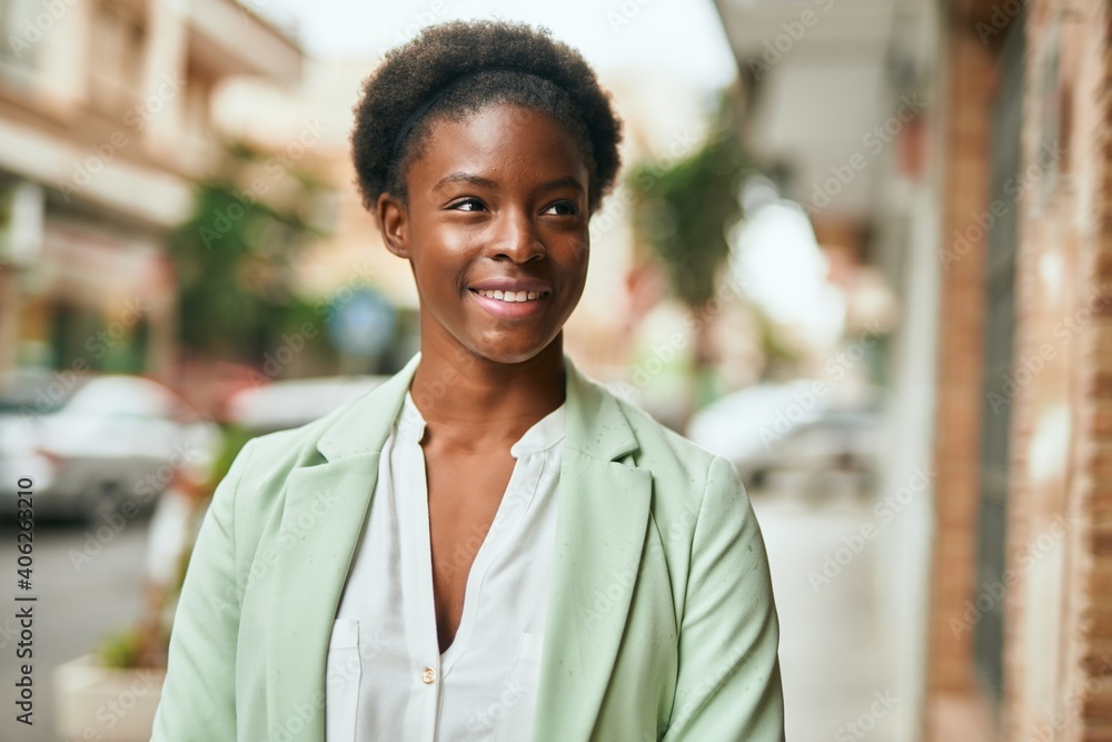 Fototapeta premium Young african american businesswoman smiling happy standing at the city