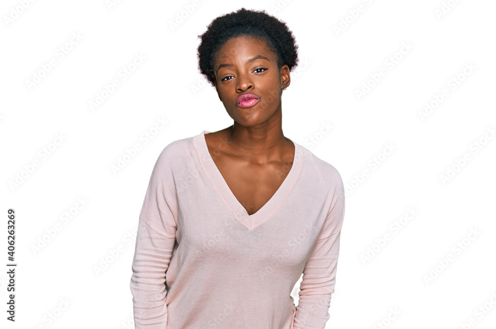 Young african american girl wearing casual clothes looking at the camera blowing a kiss on air being lovely and sexy. love expression. Young african american girl wearing casual clothes looking at the camera blowing a kiss on air being lovely and sexy. love expression.