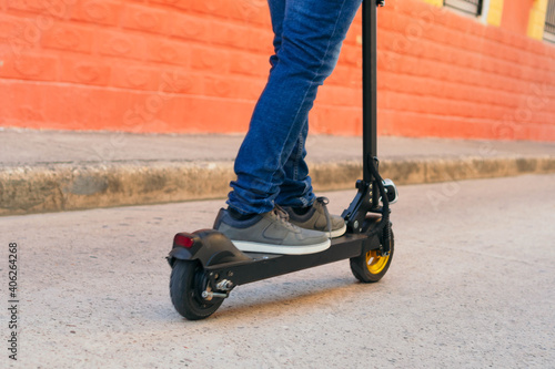 Man rides a rented electric skateboard on city streets. Man uses an electric skateboard as a means of transportation