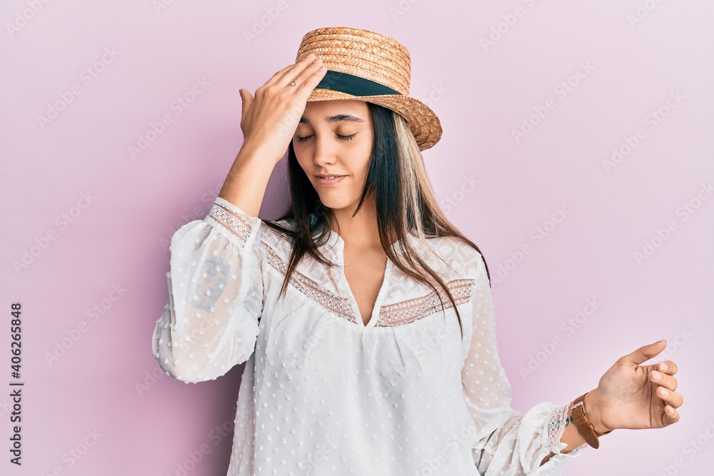 Young hispanic woman wearing summer hat surprised with hand on head for mistake, remember error. forgot, bad memory concept. Young hispanic woman wearing summer hat surprised with hand on head for mistake, remember error. forgot, bad memory concept.