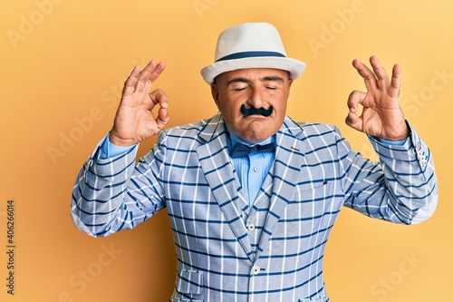 Mature middle east man with mustache wearing vintage and elegant fashion style relax and smiling with eyes closed doing meditation gesture with fingers. yoga concept.