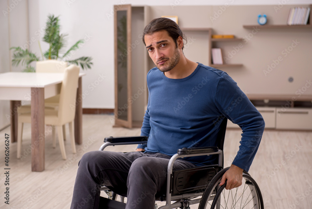 Young man in wheel-chair suffering at home Young man in wheel-chair suffering at home