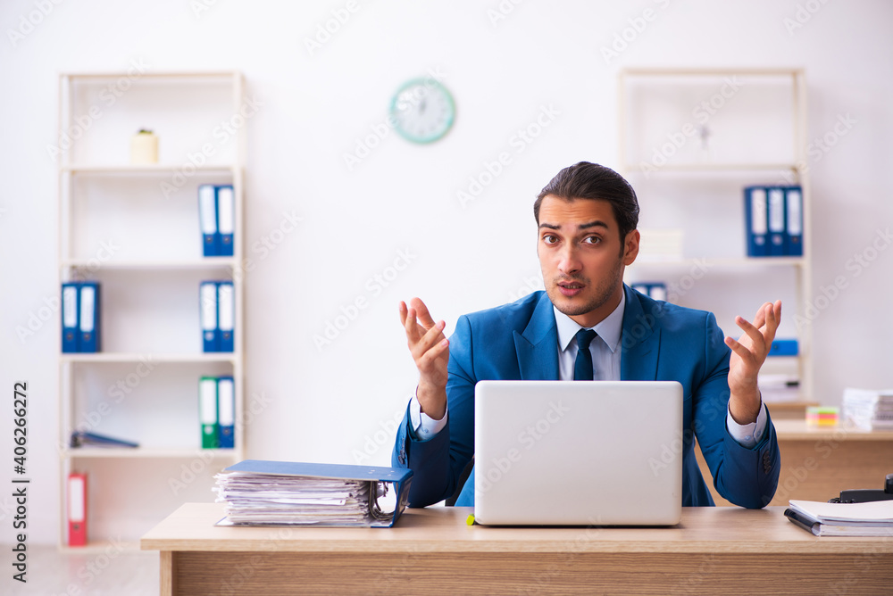 Young male employee and too many work in the office Young male employee and too many work in the office