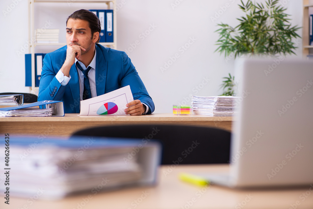 Young male sales analyst sitting in the office Young male sales analyst sitting in the office