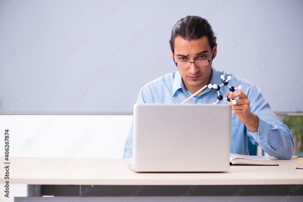 Young male physics teacher in front of whiteboard Young male physics teacher in front of whiteboard