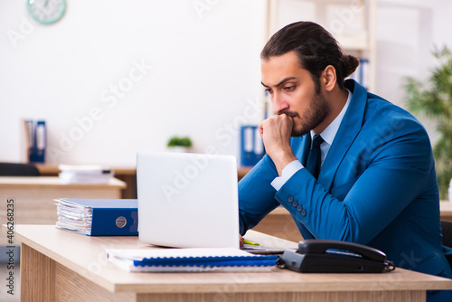 Young male employee and too many work in the office