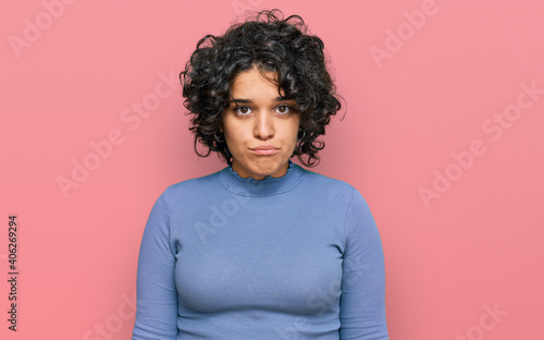 Canvas Print Young hispanic woman with curly hair wearing casual clothes depressed and worry for distress, crying angry and afraid