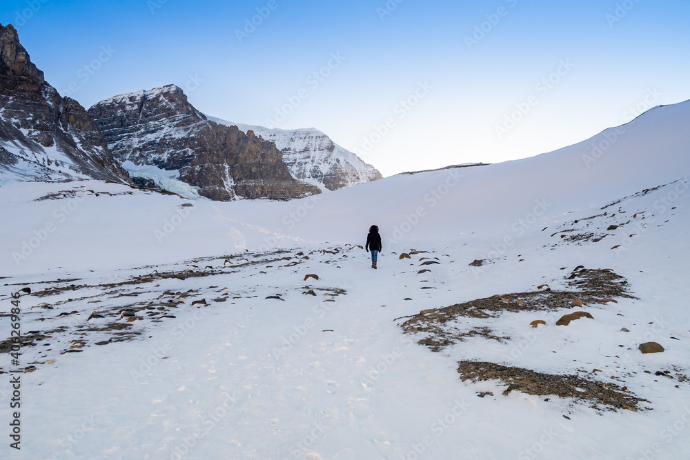 View of a woman walking towards the Athabasca glacier in the Canadian Rockies