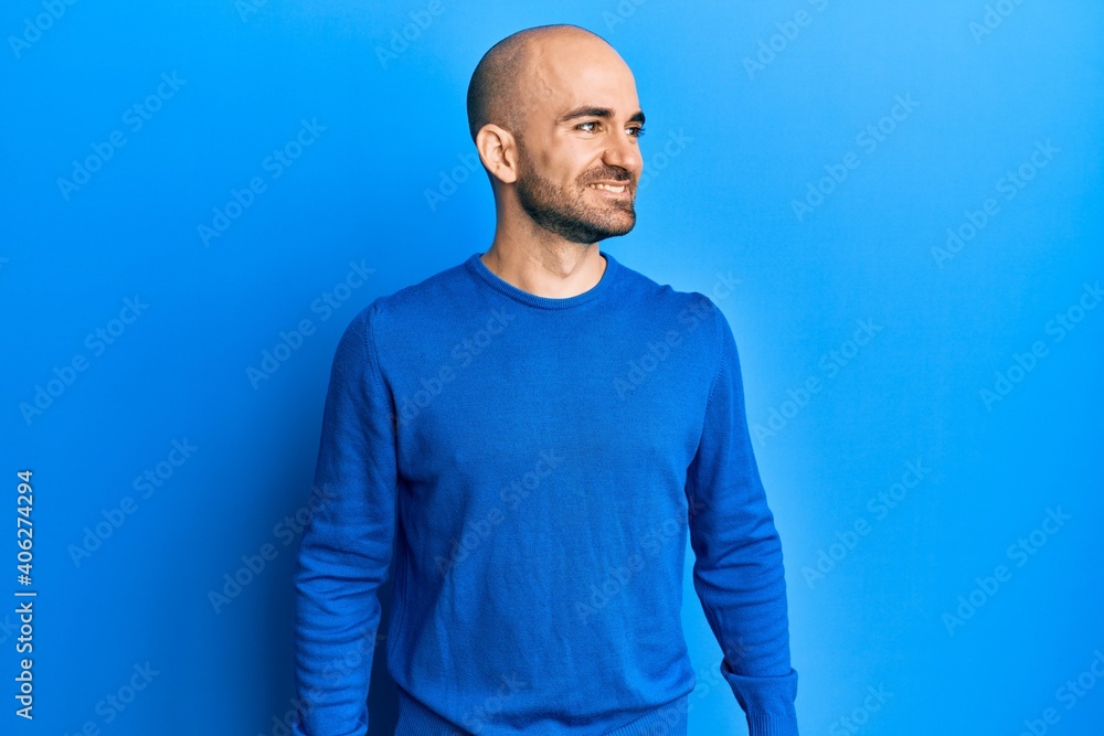 Young hispanic man wearing casual winter sweater looking to side, relax profile pose with natural face and confident smile. Young hispanic man wearing casual winter sweater looking to side, relax profile pose with natural face and confident smile.
