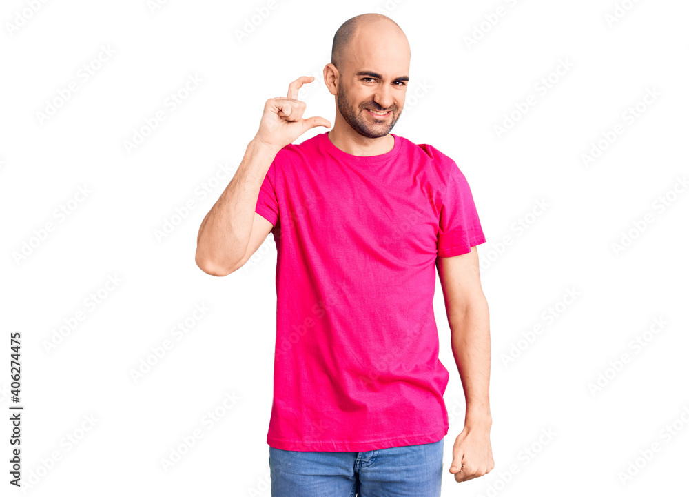 Young handsome man wearing casual t shirt smiling and confident gesturing with hand doing small size sign with fingers looking and the camera. measure concept. Young handsome man wearing casual t shirt smiling and confident gesturing with hand doing small size sign with fingers looking and the camera. measure concept.