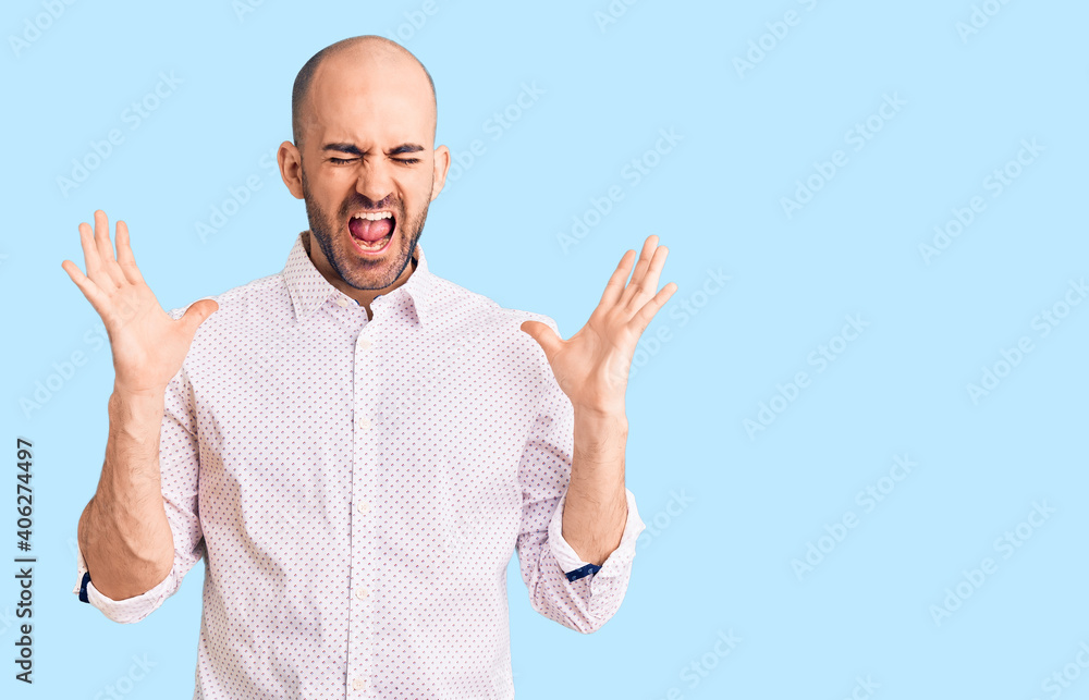 Naklejka premium Young handsome man wearing elegant shirt celebrating mad and crazy for success with arms raised and closed eyes screaming excited. winner concept