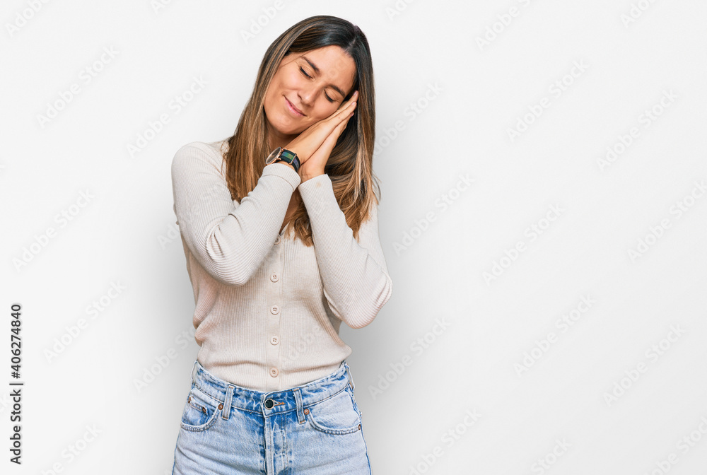 Young woman wearing casual clothes sleeping tired dreaming and posing with hands together while smiling with closed eyes. Young woman wearing casual clothes sleeping tired dreaming and posing with hands together while smiling with closed eyes.