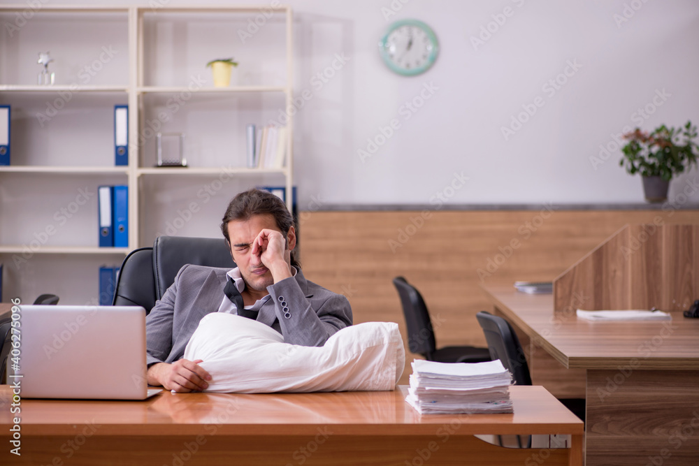 Young male employee sleeping at workplace Young male employee sleeping at workplace
