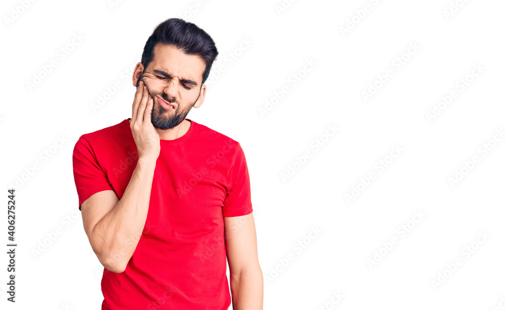 Young handsome man with beard wearing casual t-shirt touching mouth with hand with painful expression because of toothache or dental illness on teeth. dentist Young handsome man with beard wearing casual t-shirt touching mouth with hand with painful expression because of toothache or dental illness on teeth. dentist